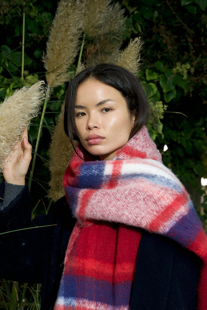 close up of woman wearing chunky red & navy plaid scarf with soft fluffy material