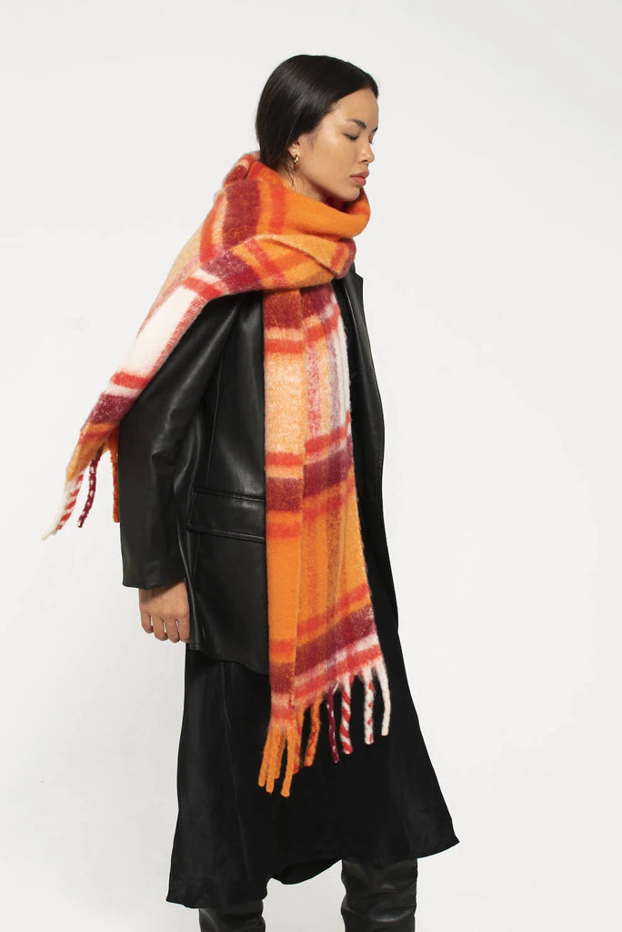 woman wearing oversized orange and red plaid scarf with soft fluffy material